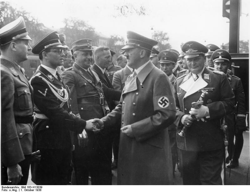 Schirach, extremo izquierdo, observa mientras Hitler saluda a su jefe de Cancillería Phillip Bouhler en Munich, 1938