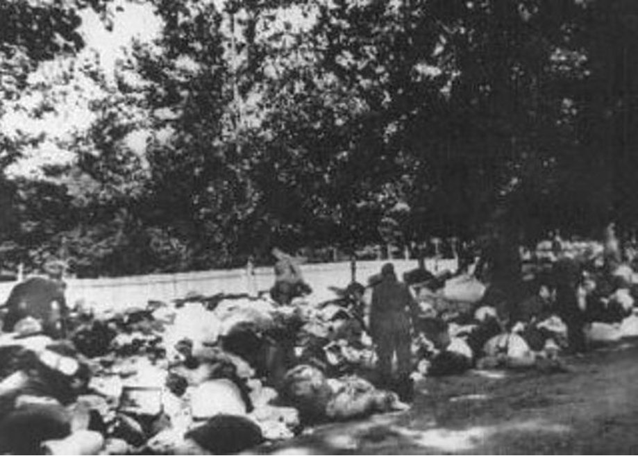 Soldados de unidades no identificados de Einsatzgruppe C revisan las pertenencias de judíos masacrados en Babi Yar, un barranco cerca de Kiev. Unión Soviética, 29 de septiembre a 1 de octubre de 1941