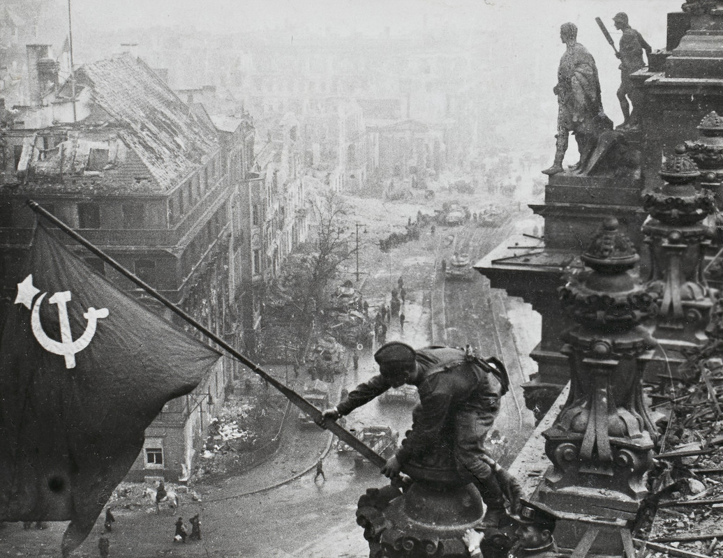 El soldado soviético Melitón Kantaria alza la bandera de la URSS y reemplaza la de la Alemania Nazi sobre el techo del parlamento del Reich. La fotografía fue tomada por el fotógrafo Yevgeni Jaldéi