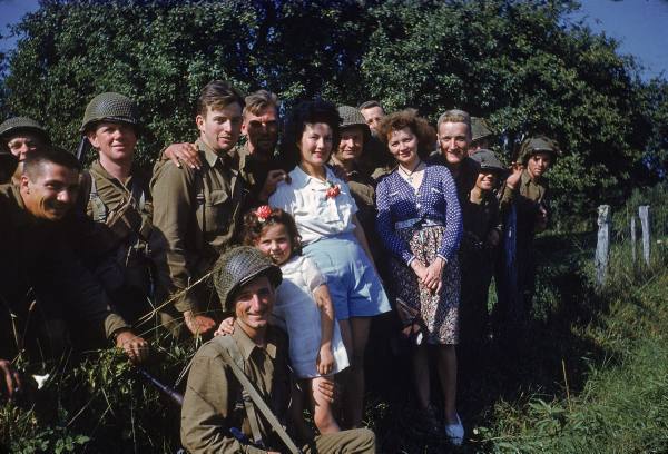 Dos mujeres y una niña francesa posan en Avranches junto a algunos soldados americanos