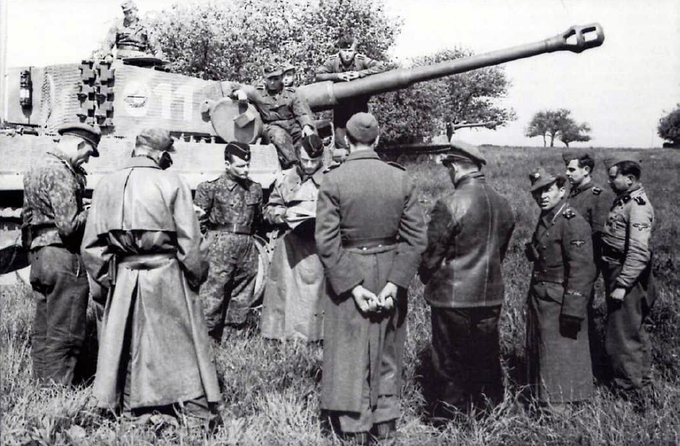 Los comandantes de una compañía de Tiger I recibiendo instrucciones antes de una misión. La uniformidad es de lo más variada