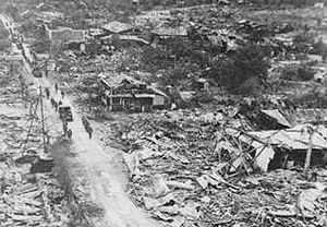 Una columna estadounidense atraviesa una población destruida en la isla de Saipán