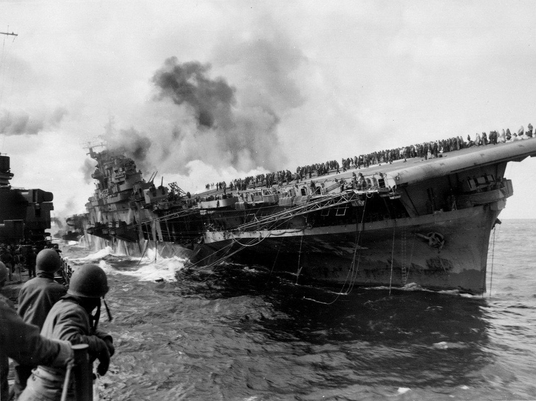 El USS Franklin CV-13 escorado, en llamas y con la tripulación en cubierta el 19 de marzo de 1945, visto desde el crucero Santa Fe