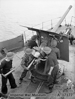 La tripulación de un arrastrero armado carga un cañón de 12 libras a proa de la nave