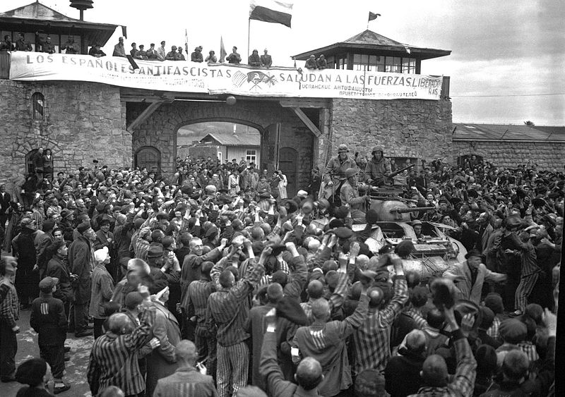Fotografía tomada el 6 de mayo de 1945 en la que se ve a prisioneros del campo de concentración de Mauthausen saludar la entrada de la 11ª División Acorazada de EEUU, bajo una pancarta escrita en español, en la que se lee Los españoles antifascistas saludan a las fuerzas liberadoras