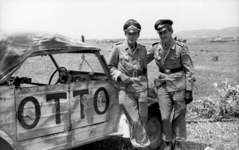 Norte de África. Hans-Joachim Marseille luciendo la Cruz de Caballero y un sargento piloto de la Luftwaffe junto a un automóvil VW-Kübelwagen con el nombre de Otto