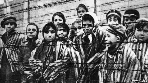 Niños detrás de una valla de alambre de púas en el campo de concentración de Auschwitz