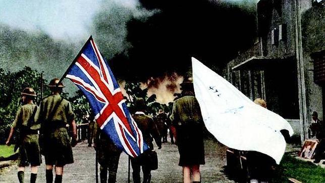 Oficiales británicos, que portan la bandera del Reino Unido y una enseña blanca, son conducidos por militares japoneses en el acto de rendición de Singapur
