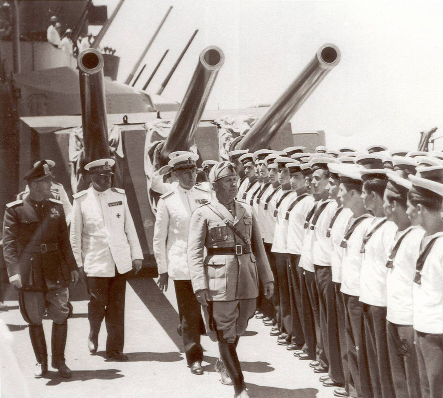 A bordo del Acorazado RMI Littorio, Benito Mussolini, acompañado por el secretario del partido fascista Vidussoni, el Jefe de Estado Mayor de la Marina Real, el Almirante Riccardi, y el comandante de la flota, el Almirante Iachino, pasan revista a la tripulación después de la Batalla de mediados de julio. Taranto, el 21 de junio de 1942
