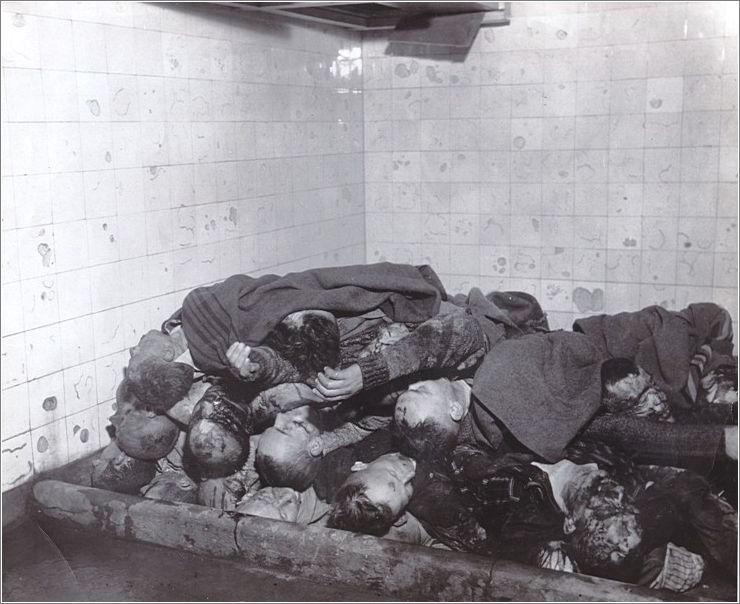 Los cuerpos de prisioneros muertos yacen apilados a la espera de ser quemados