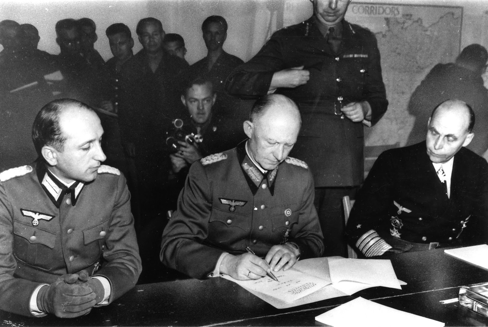 Alfred Jodl en el centro, Wilhelm Oxenius a la izquierda y Hans-Georg von Friedeburg a la derecha, firmando el documento de rendición ante la delegación aliada, en Reims, Francia 07 de mayo 1945