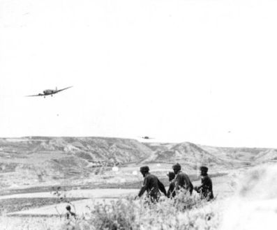 Un Ju 52 lanzando paracaidistas en un poco profundo valle, probablemente el valle de la Prisión
