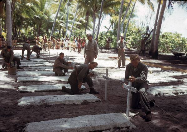 Hombres preparando cruces, mientas otro prepara un cartel para el cementerio de la 2ª División de Marines en Tarawa, 1944