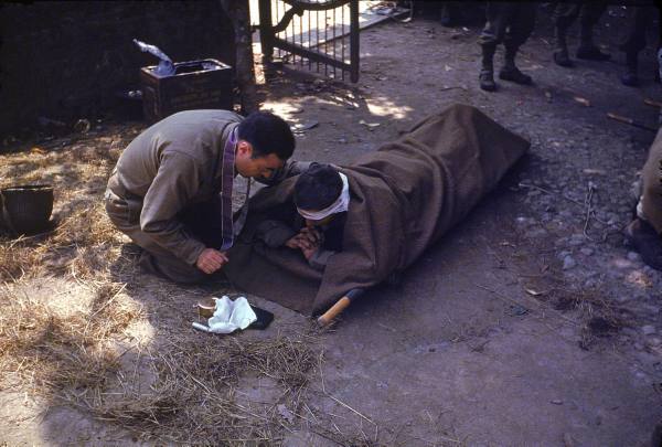 Un Capellán del ejército americano proporciona la eucaristía a un soldado herido