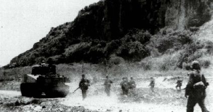 Una escuadra de fusileros de la 2ª División de Marines escoltado a un tanque M4A2 Sherman en Saipán