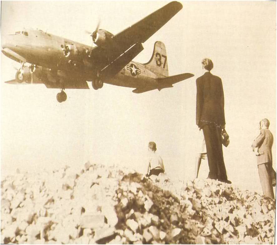 Berlineses observan uno de tantos aviones que rompieron el cerco ruso