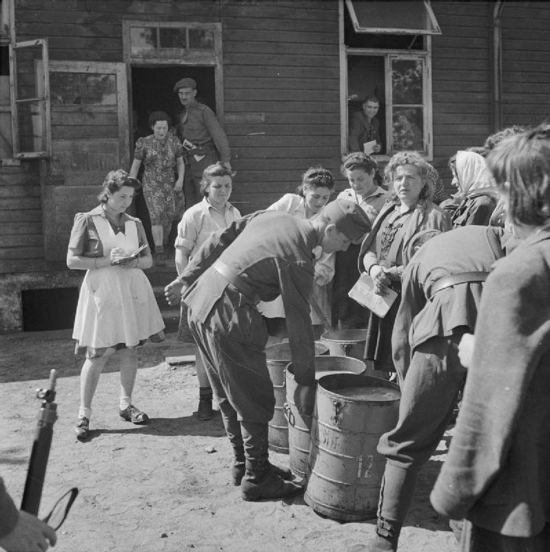 Un soldado húngaro entrega alimentos a mujeres. Dos comidas se proporcionaron todos los días a las 7 am y 13.00
