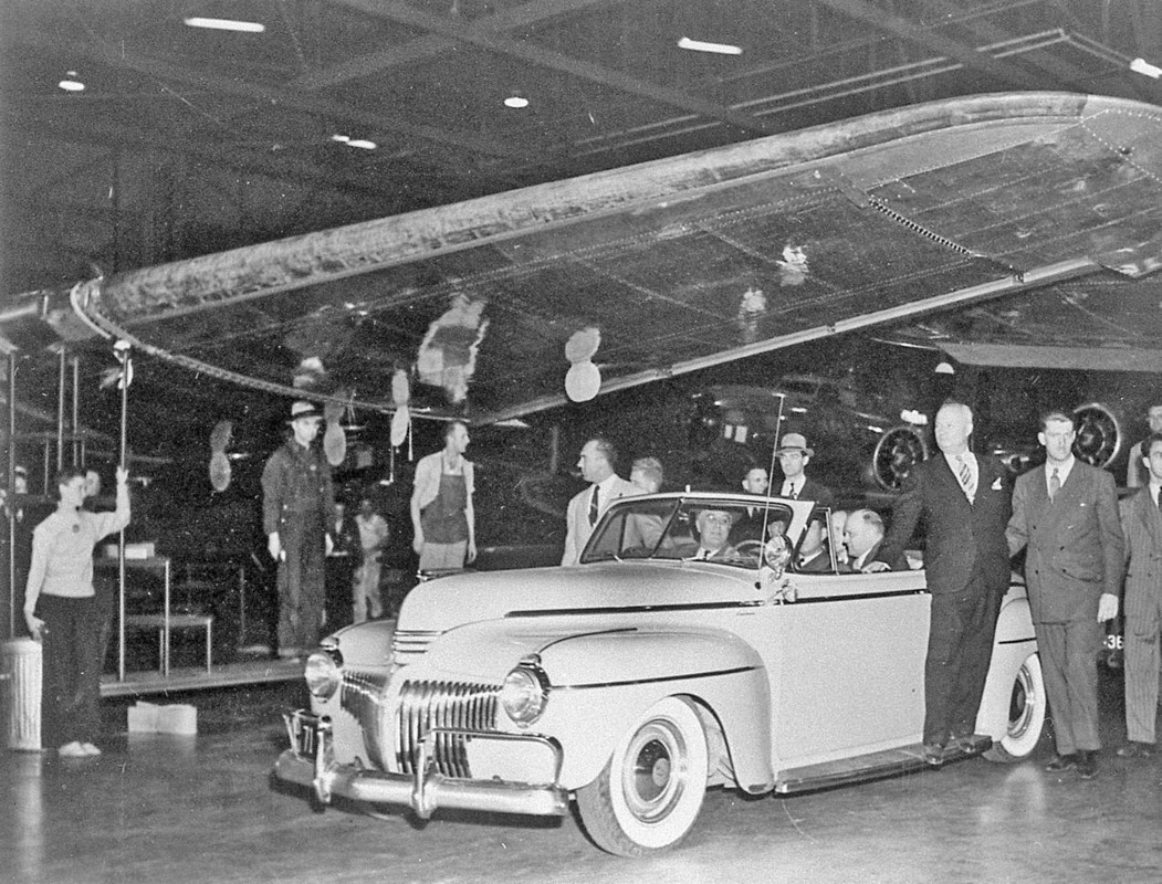 Franklin D. Roosevelt en un auto que recorre la planta de Boeing en Seattle en 1942. El automóvil pasa bajo ala de un B-17F