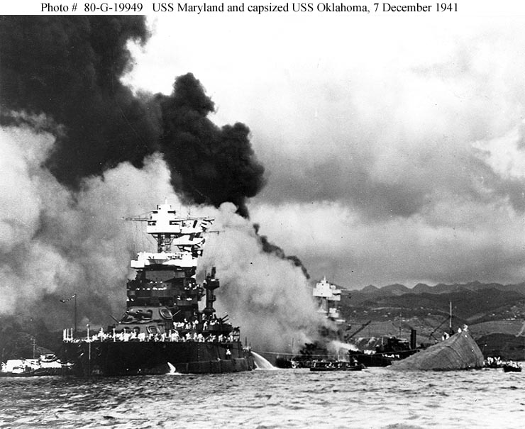 USS Maryland junto al escorado USS Oklahoma BB-37, el USS West Virginia BB-48 en llamas  al fondo de la fotografía