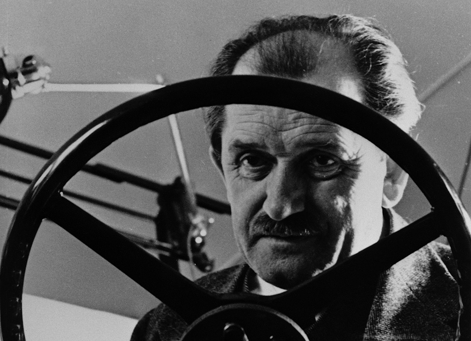 Retrato de 1935 del Dr. Ferdinand Porsche detrás de un volante