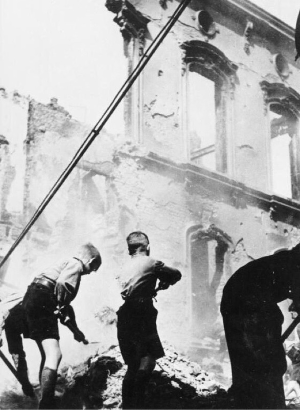 Miembros de las HJ están limpiando las ruinas de un edificio bombardeado en Alemania