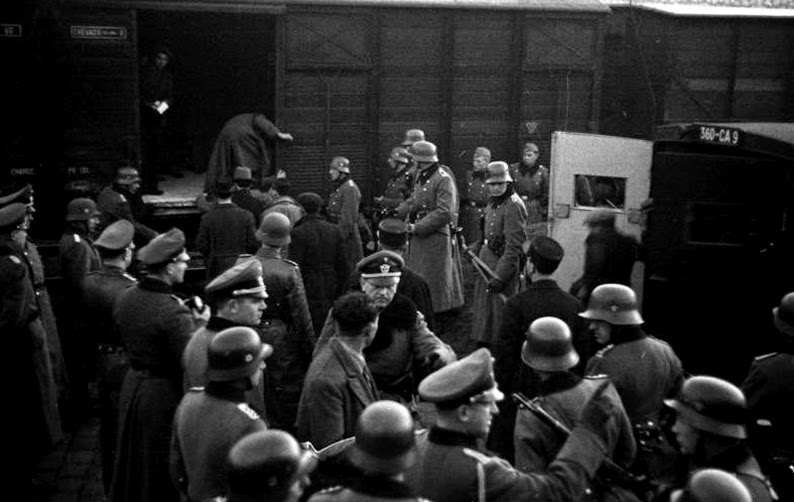 Tropas de los batallones de Policía carga judíos en vagones de carga en Marsella, Francia en enero de 1943