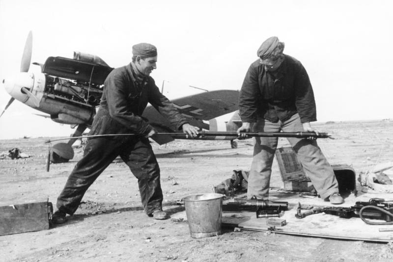 Equipo de mantenimiento de Marseille, Hoffmann, izquierda, y Berger, limpiando las armas de un Bf 109 Amarillo 14 que se ve al fondo