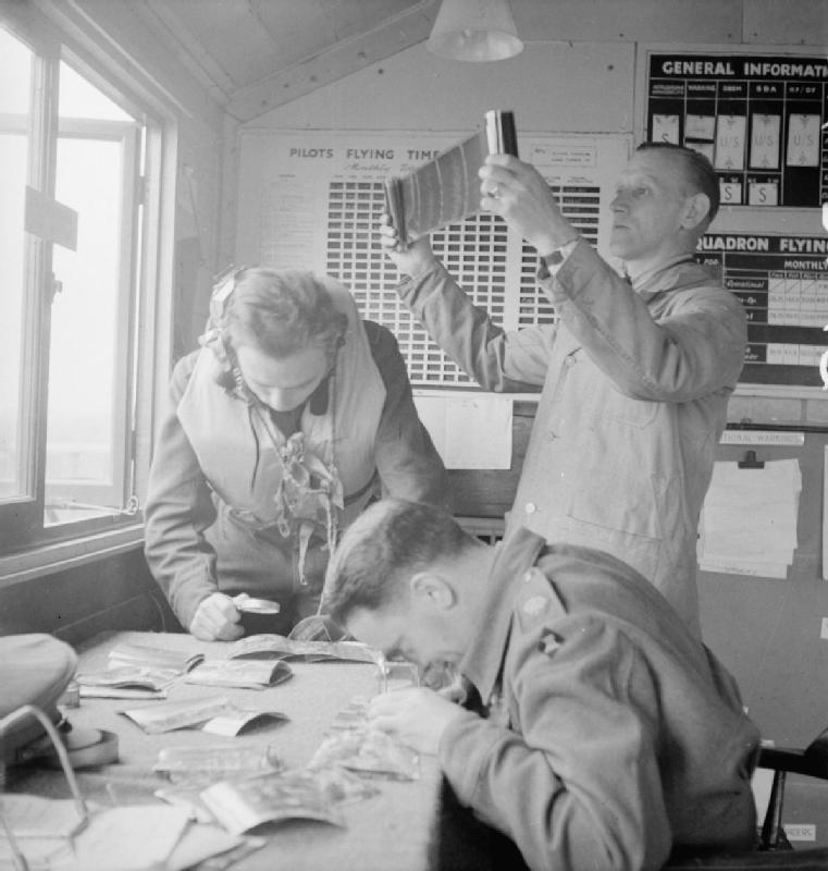 Piloto y personal de tierra del 2º Escuadrón observando unas fotografías realizadas por el escuadrón