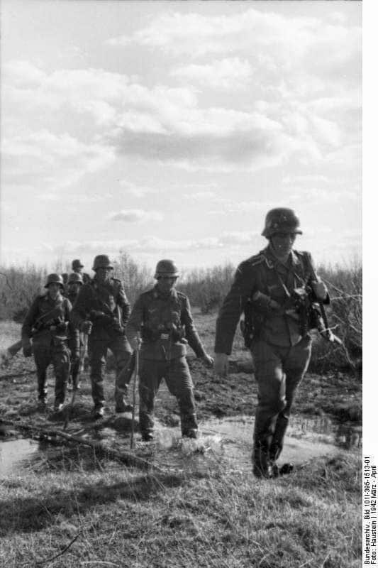 Soldados de una unidad de la Luftwaffe desplegada en tierra en patrulla sobre terreno pantanoso. Unión Soviética, marzo de 1942