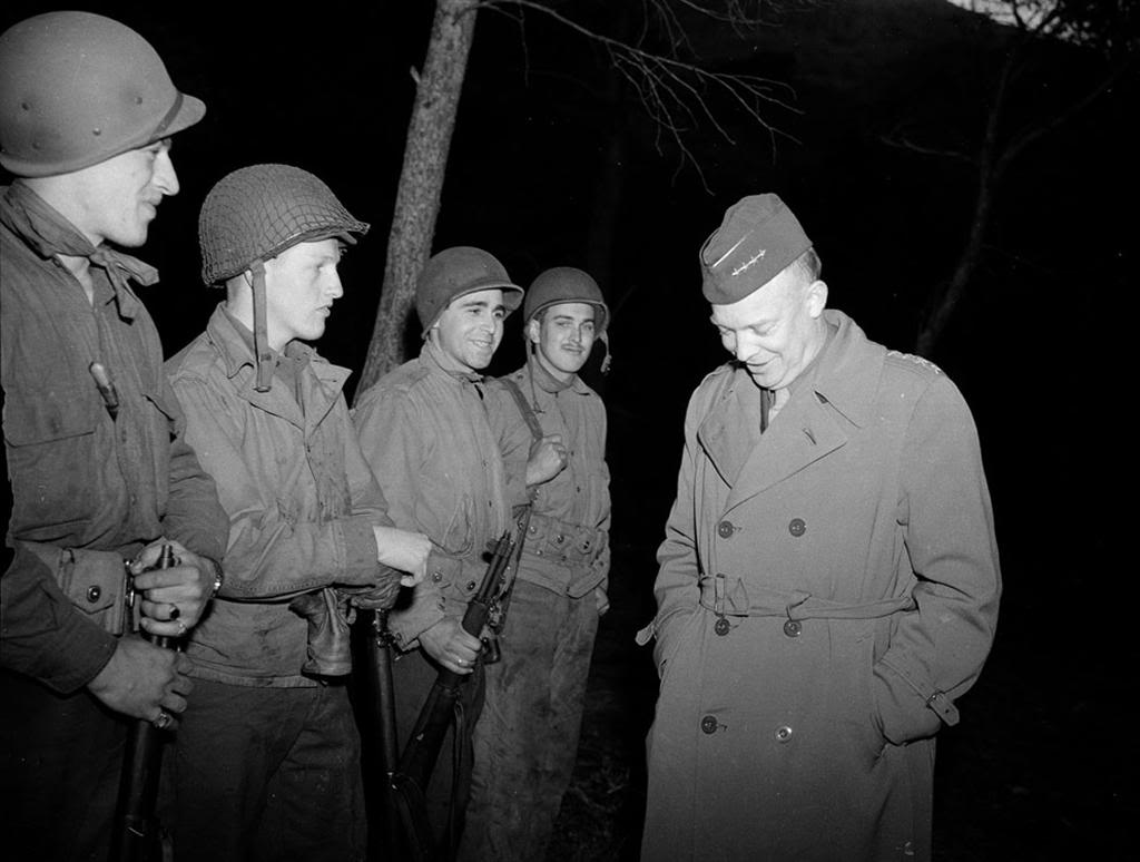 El General Eisenhower charla con unos soldados en el norte de África. Tanto el primero como el tercer soldado empezando por la izquierda, portan únicamente el casco ligero, fabricado en fibra de cartón