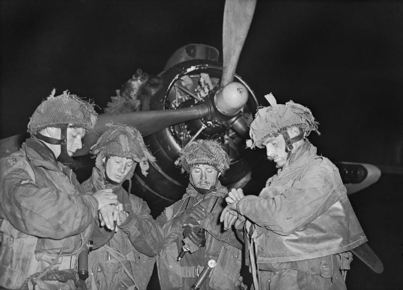 Los Tenientes Bobby de la Tour, Don Wells, John Vischer y Bob Midwood pertenecientes a la 22ª Compañía independiente de Paracaidistas, de la 6ª División Paracaidista, consultan sus relojes delante del motor de un Armstrong Whitworth Albemarle, perteneciente al Grupo Nº 38 de la RAF, en el Aeródromo de Harwell, en Oxfordshire, en la noche del 5 al 6 de junio de 1944