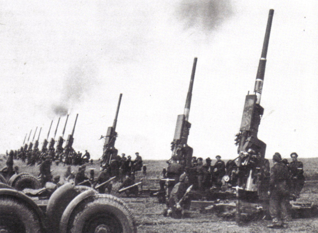Una batería completa de doce cañones de QF 3,7 de 94 mm dispara una salva para festejar la victoria en mayo de 1945 en Larkhill, Salisbury