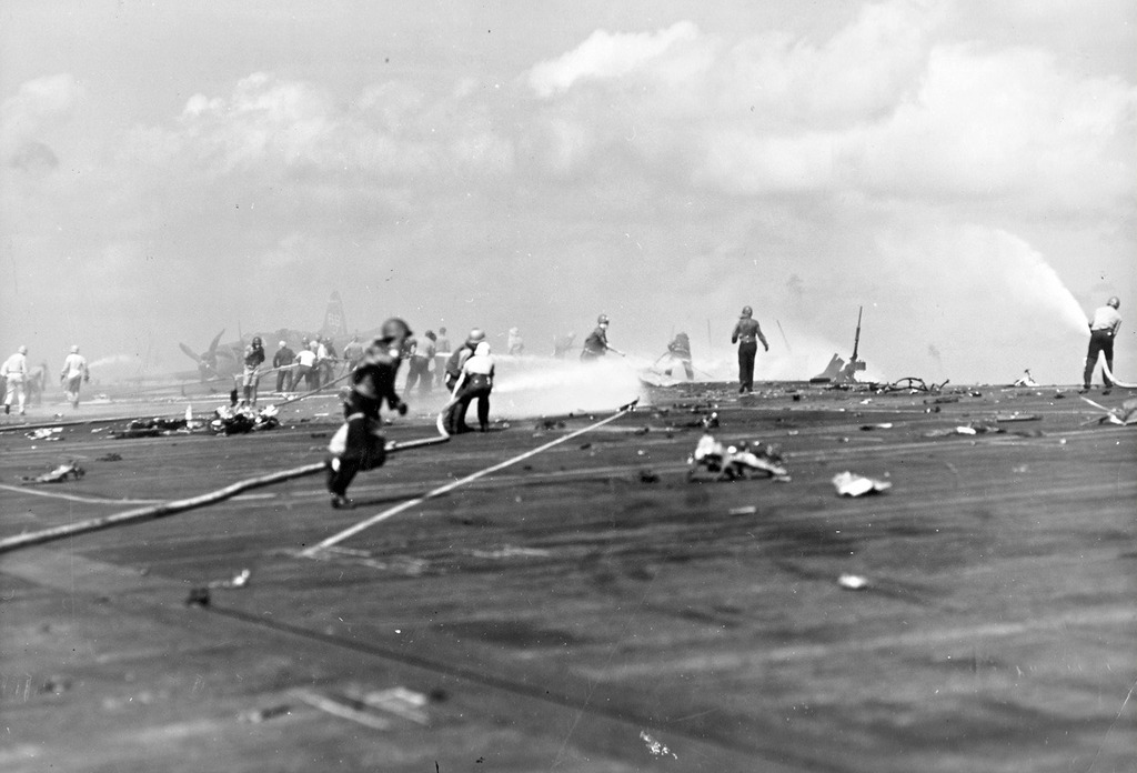 Consecuencias del 25 de noviembre 1943 ataque kamikaze contra el USS Essex. Los bomberos y los fragmentos dispersos de los aviones japoneses cubren la cubierta de vuelo. El avión se estrelló contra el borde del puerto de la cubierta de vuelo, el aterrizaje de los aviones alimentados para despegar, causando grandes daños, matando a 15 e hiriendo a 44