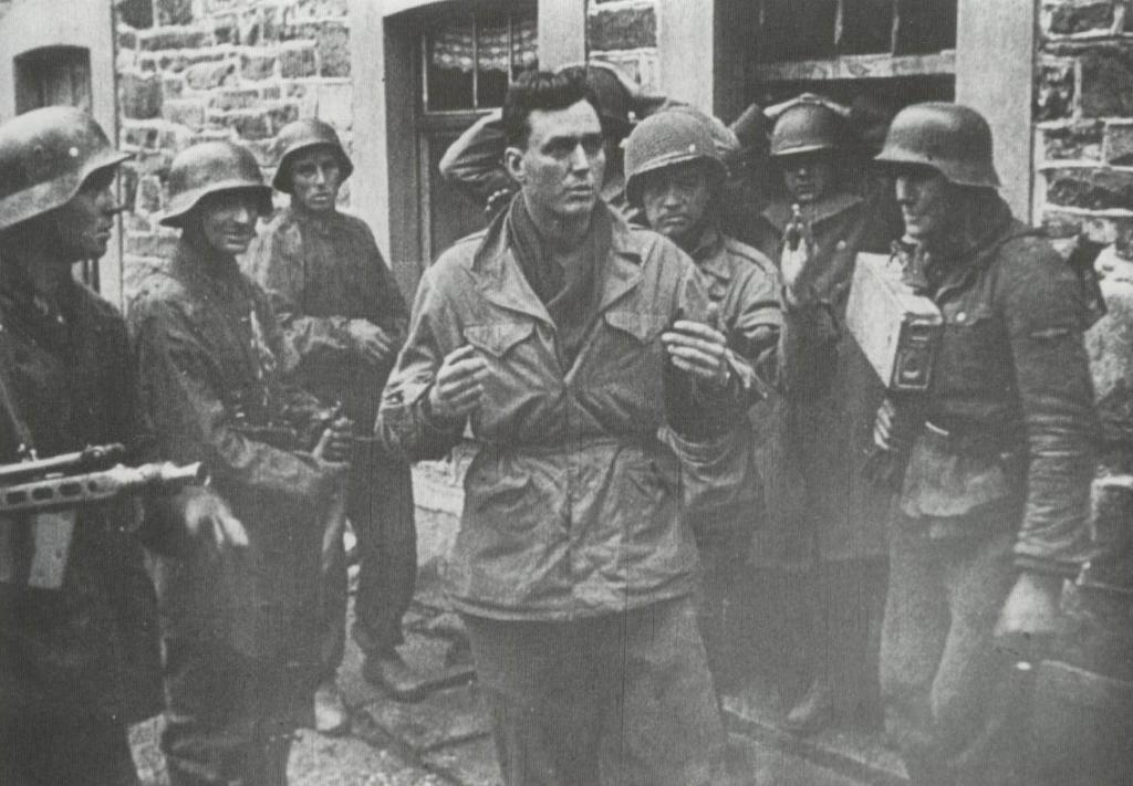 Prisionero norteamericano del 3er batallón del 119 regimiento de Infantería son sacados de un edificio por por confiados granaderos del III SS PzGren Rgt.2