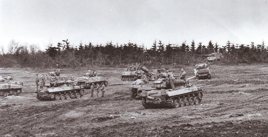 Un grupo de M18 de la 6ª División Blindada se detiene ante un tanque destruido MK VI King Tiger en algún lugar de Alemania, el 28 de febrero de 1945