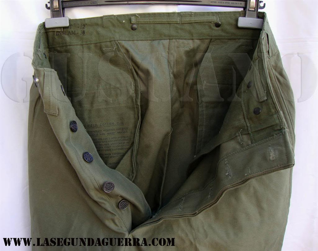 Esta otra variante del pantalón M-43, Trousers, Field, Cotton, O.D., según la denominación oficial, se fabricó con botones metálicos y carece de botones de ajuste en la perneras. Las instrucciones de uso están marcadas con tinta en el interior