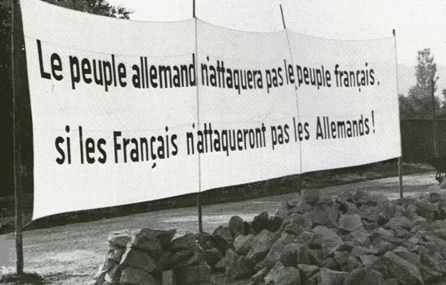 Una pancarta en el lado alemán dice El pueblo alemán no atacará al pueblo francés, si los franceses no atacan a los alemanes, más propaganda para mantener el frente inactivo