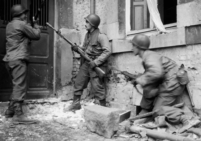 Fusileros del 117ª de Infantería de la 30ª División se prepara para echar a bajo una puerta en Stavelot, el 21 de diciembre
