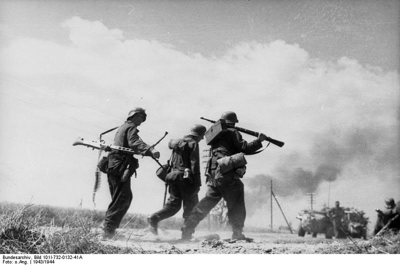 Equipo de MG-42 en Rusia, verano de 1943. El tirador lleva la ametralladora enganchada mediante una correa y con el bipode acoplado. Se puede ver que la cinta de proyectiles cuelga del arma. Uno de sus ayudantes lleva un fusil Kar 98K al hombro y una caja con munición para la MG-42