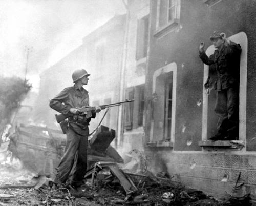 Soldado estadounidense tomando prisionero a un oficial alemán al que apunta con su rifle automático BAR