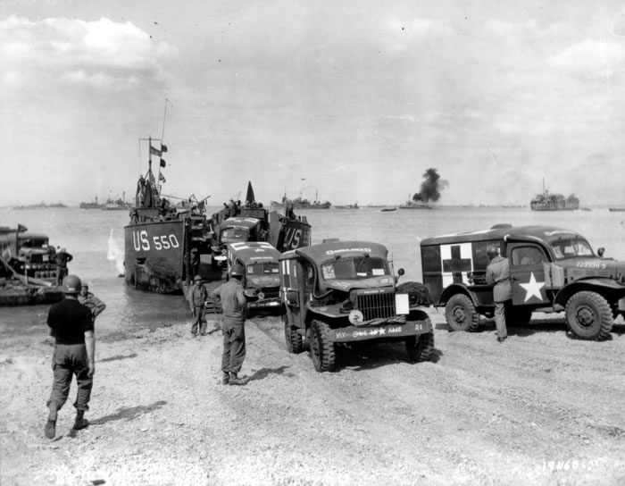 Desembarco en la Playa de Omaha a mediados de junio de 1944. Entre los vehículos desembarcados se encuentran Ambulancias Dodge WC-54