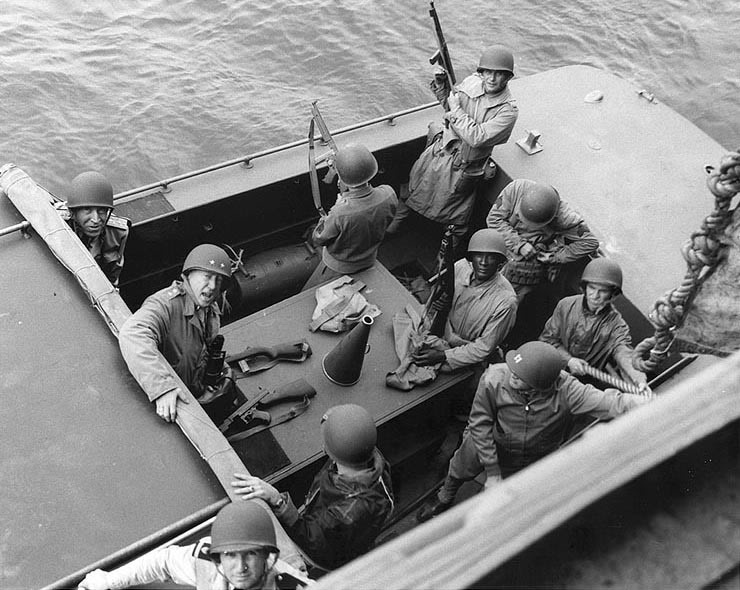 George S. Patton, U.S. Army y el Vicealmirante John L. Hall, USN, detrás de Patton, se preparan para desembarcar en las playas norteafricanas. La foto fue tomada alrededor del 9 de Noviembre de 1942, cuando Patton desembarcó por primera vez en Fedhala, Marruecos. A destacar el grupo de guardaespaldas de Patton, armados todos ellos con subfusiles Thompson M-1, así como la Carabina M-1 al lado del General