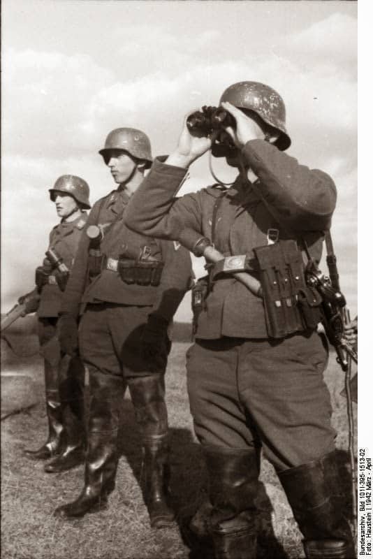 Tres soldados de una división de campo de la Luftwaffe observando con prismáticos. Unión Soviética, marzo de 1942