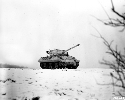 Pintado de blanco para mezclarse con el terreno cubierto de nieve, un M-36 cruza un campo, Dudelange, Luxemburgo, 3 de enero de 1945