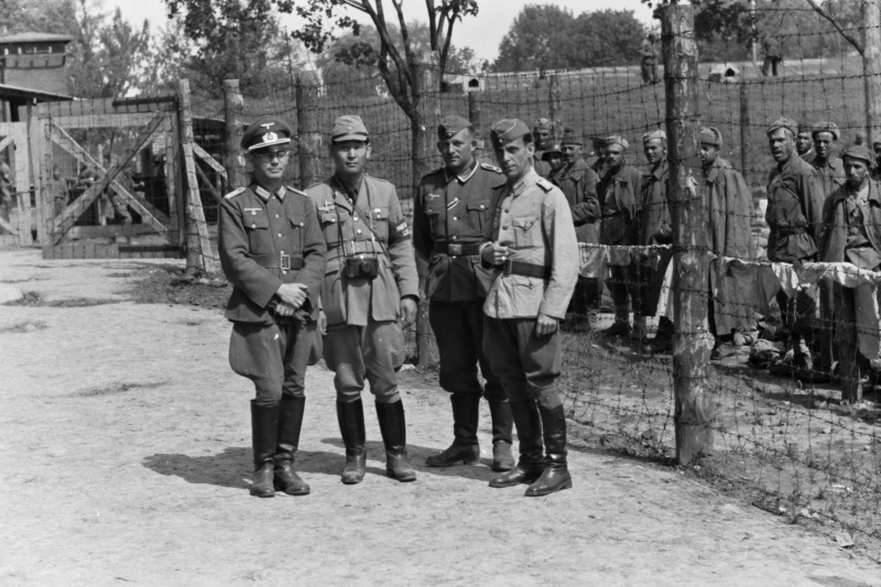 Un par de cuadros del ejército alemán, posan junto al corresponsal de guerra japonés Sunji Sasamoto y un colega del 2º Ejército húngaro, a las puertas de un campo de prisioneros soviéticos