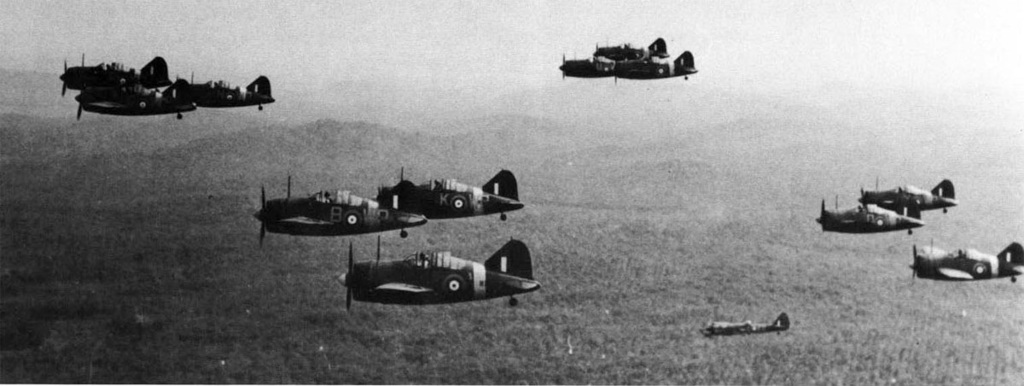 Doce Brewster Buffalo del Escuadrón Nº 243 de la RAF, con base en Kallang, Singapur, en vuelo sobre la selva malaya, acompañados por un Bristol Blenheim Mark IV del Escuadrón Nº 34 Escuadrón de la RAF, inferior derecha, con base en Tengah