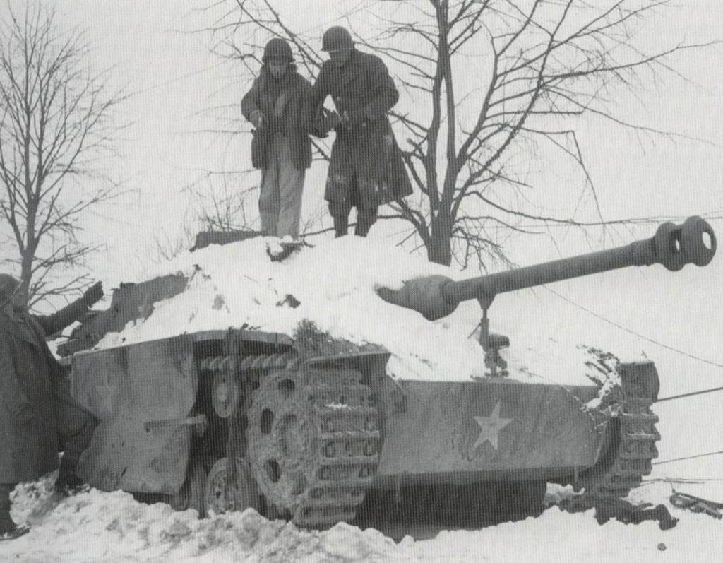 Un Sturmgeschütz del Kampfgruppe Y abandonado en Géromont, fotografiado el 15 de enero mientras el Teniente John Perkins, el Cabo Peter Piar y el Soldado Calvin Dupre del 291 de Ingenieros retiran una bomba trampa