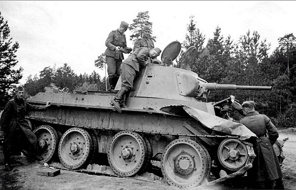 Soldados inspecciona un BT-7 destruido durante la invasión de Rusia