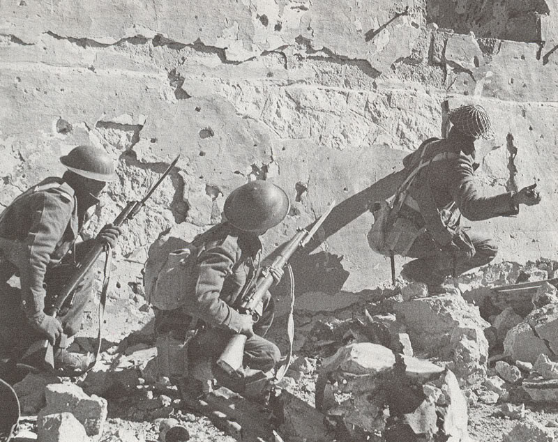 Soldados sudafricanos se aprestan a asaltar una posición en Sollum, Egipto, 1942. Dos están armados con fusiles Lee-Enfield Nr 1 Mk III con bayoneta calada, y el otro con una granada de mano