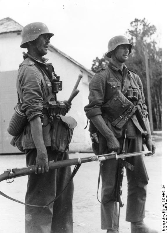 Dos soldados alemanes en la URSS, verano de 1941. El más cercano lleva un fusil Kar 98K con bayoneta calada, y el otro sostiene vagamente por la correa un subfusil MP-40 con la culata desplegada